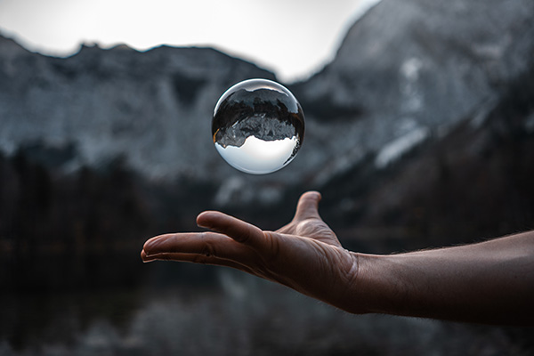 Eine Hand mit einer schwebenden Glaskugel